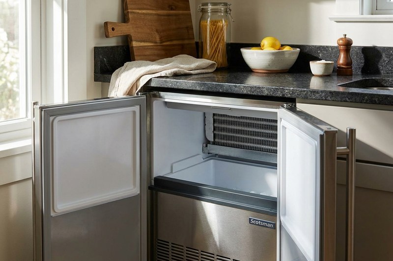 Undercounter ice maker with doors open showing the ice bin